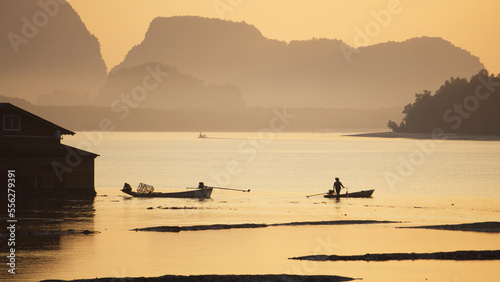 Silhouette of people talking each other while sitting on the wooden boats in the morning at Ban Sam Chong Tai, Ta Kua Thung, Phangnga, Thailand. © Ploypilin