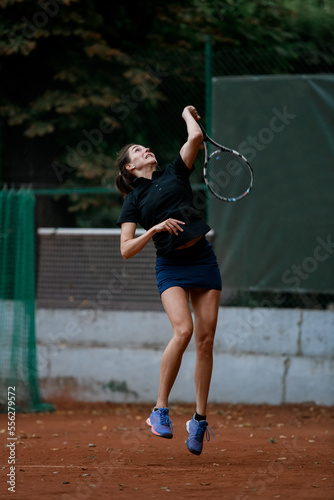 front view of active bouncing female tennis player with tennis racket in her hand behind her back