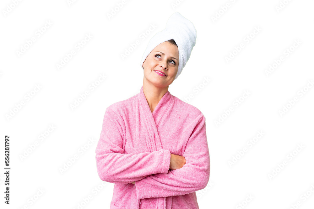 Middle age caucasian woman in a bathrobe over isolated background looking up while smiling Middle age caucasian woman in a bathrobe over isolated background looking up while smiling