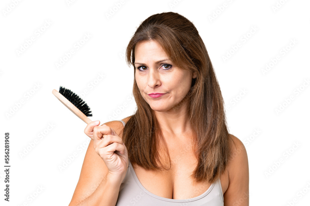 Middle age woman over isolated background with hair comb Middle age woman over isolated background with hair comb