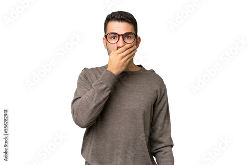 Young handsome caucasian man over isolated background covering mouth with hand