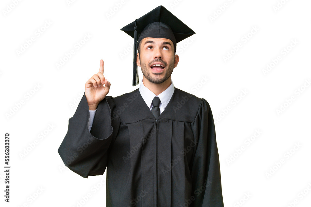 Young university graduate man over isolated background pointing up and surprised