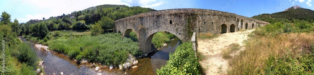 Ancient roman aqueduct passing Agly river and Pic de Vergès mountain near the old village of Ansignan, Occitanie in France