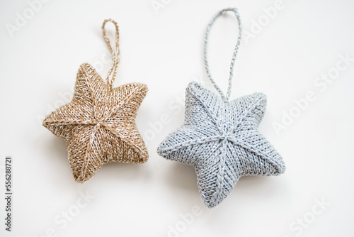 knitted decorations for the Christmas tree. handmade. do it yourself golden and silver stars on a white background. place for writing. free space.