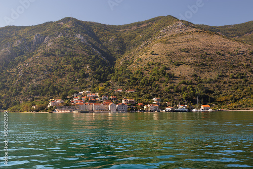  Red roof coastal town on the shore of Kotor bay. Montenegro mountains as background. Adriatic sea.
