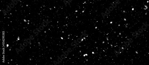 Falling snow flakes, Flying dust particles on a black background. Abstract winter background. Winter landscape with falling shining beautiful snow.