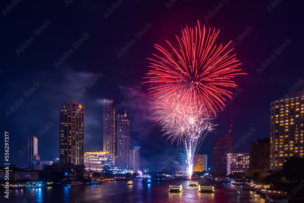 Colorful Firework at river with cityscape night light view of Bangkok skyline at twilight time..New Year celebration fireworks, Thailand.Fireworks light up to sky at Christmas and New Year festival
