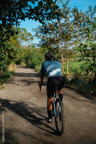 A young bearded cyclist is biking through a dirt path. © Jonathan De Guzman