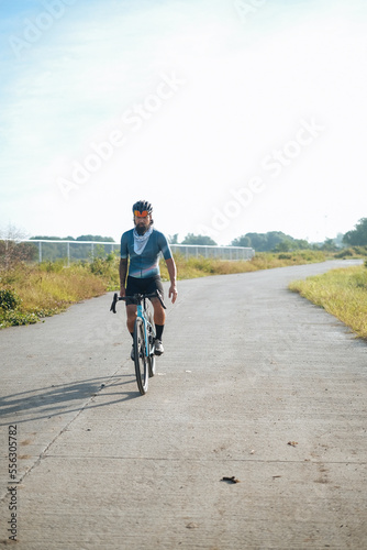 Fototapeta Naklejka Na Ścianę i Meble -  A young bearded cyclist is biking with no hands
