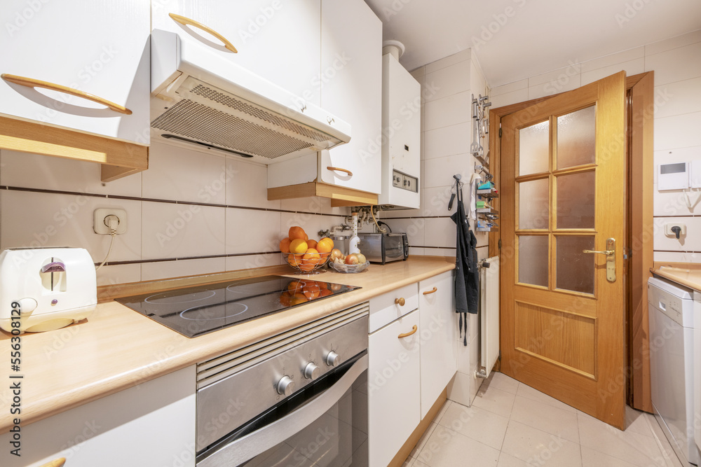kitchen with white wood cabinets with white built-in appliances, natural gas hot water heater and wood countertop kitchen with white wood cabinets with white built-in appliances, natural gas hot water heater and wood countertop