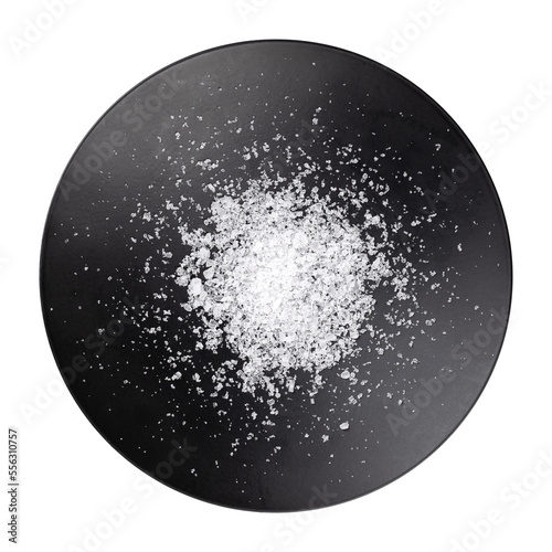 Sea salt, fleur de sel, in a flat black bowl. Also known as flor de sal, a salt that forms a thin, delicate crust on the sea water that evaporates. Used as a finishing salt to flavor and garnish food.
