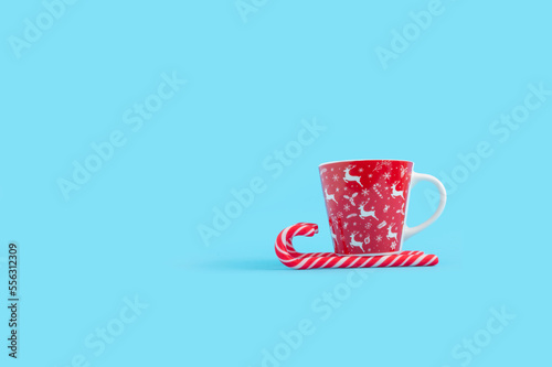 Minimal New year and Christmas concept with candy cane and coffee mug.