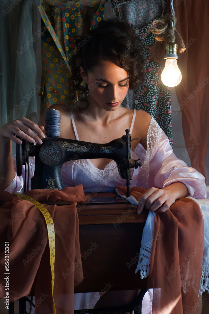 Young vintage girl intent on sewing by machine