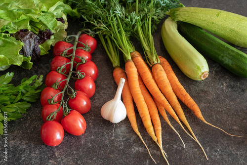 Farm vegetables (tomatoes, carrots, lettuce) on the table