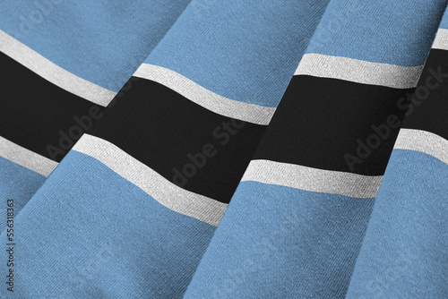 Botswana flag with big folds waving close up under the studio light indoors. The official symbols and colors in fabric banner photo