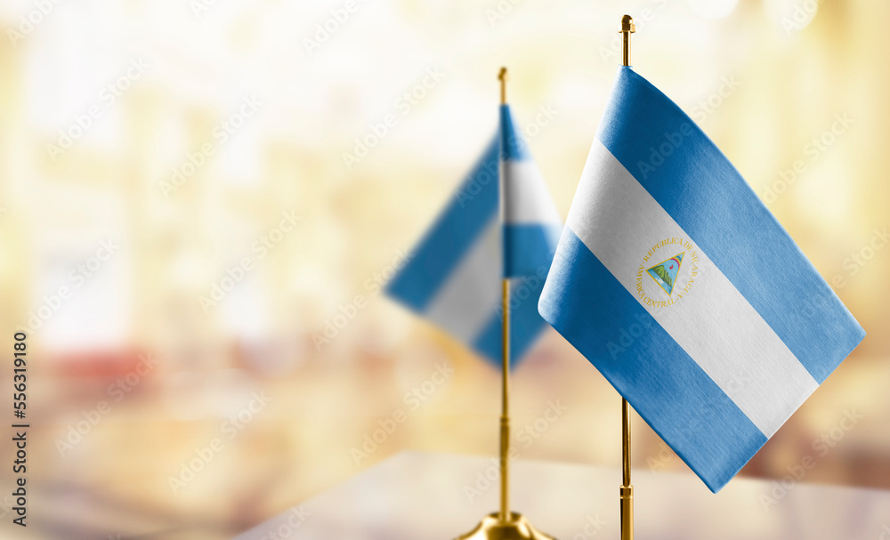 Small flags of the Nicaragua on an abstract blurry background