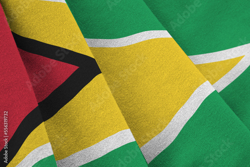 Guyana flag with big folds waving close up under the studio light indoors. The official symbols and colors in fabric banner photo