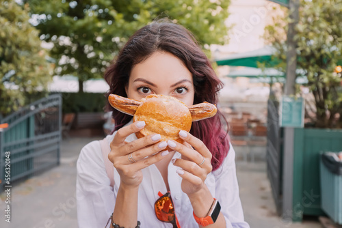 Photography A happy girl eats an appetizing traditional German bratwurst hot dog with juicy