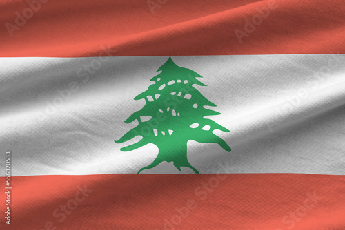 Lebanon flag with big folds waving close up under the studio light indoors. The official symbols and colors in fabric banner
