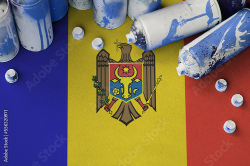 Moldova flag and few used aerosol spray cans for graffiti painting. Street art culture concept, vandalism problems