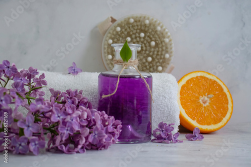 Massage brush  cream  lilac flower  orange on a light background