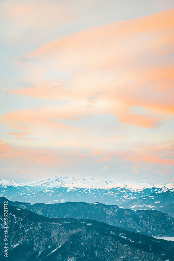 dreamy clouds and mountains covered with snow in wintertime, sunset in mountains