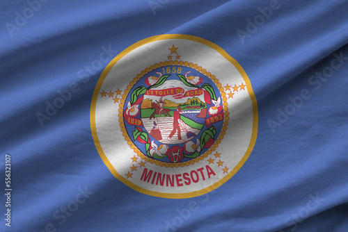 Minnesota US state flag with big folds waving close up under the studio light indoors. The official symbols and colors in fabric banner photo