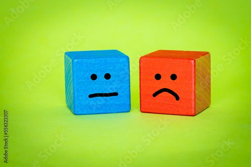 Emotions, Blue and Red Wooden Block, Hand Painted Facial Expression, Sadness and Disappointment, Dissatisfaction, Green Background