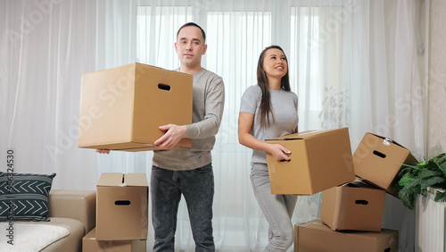 Husband and wife unpack boxes to prepare new apartment for arrangement and decoration. Married couple enjoys moving into new property together © lenblr