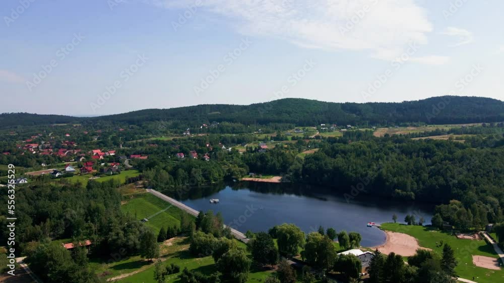 Aerial view of mountain village near lake with green meadow for camping at sunny summer day. Place to relax in nature. Aerial view of mountain village near lake with green meadow for camping at sunny summer day. Place to relax in nature.