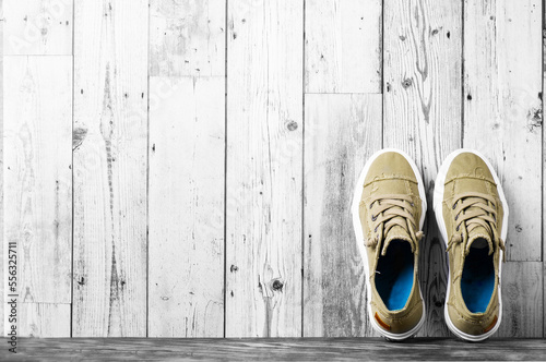 retro hipster sneakers with white laces stand against a gray wall on the floor. Banner. Space for text.