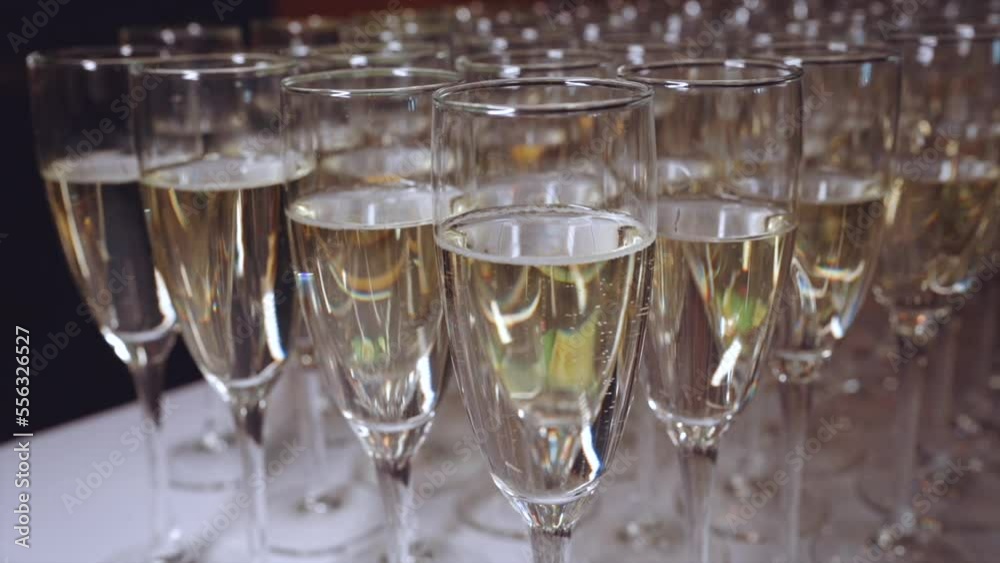 Beautifully illuminated glasses of champagne, champagne at a buffet, glasses of champagne in slow motion Beautifully illuminated glasses of champagne, champagne at a buffet, glasses of champagne in slow motion