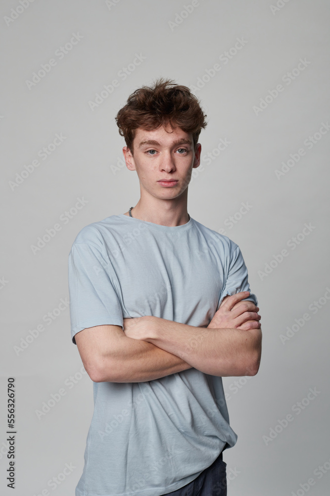 Young boy looking at the camera with his arms folded