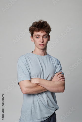 Young boy looking at the camera with his arms folded
