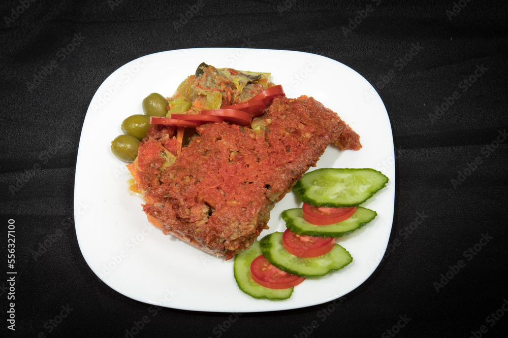Potatoes and meat with vegetables in tomato sauce on a white plate Potatoes and meat with vegetables in tomato sauce on a white plate