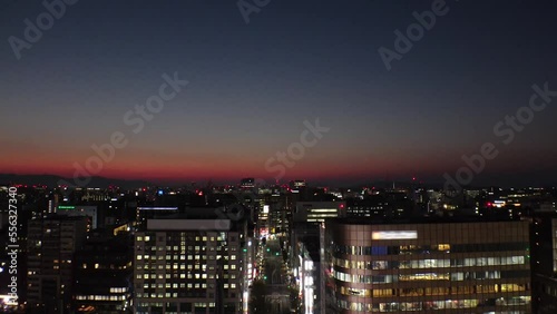 HAKATA, FUKUOKA, JAPAN - NOVEMBER 2022 : Aerial high angle view of cityscape of Fukuoka city in sunset. View of Tenjin and Nakasu downtown area from Hakata station. Time lapse shot. photo