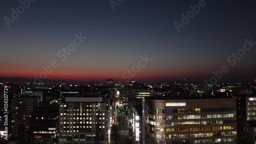 HAKATA, FUKUOKA, JAPAN - NOVEMBER 2022 : Aerial high angle view of cityscape of Fukuoka city in sunset. View of Tenjin and Nakasu downtown area from Hakata station. Time lapse shot. photo