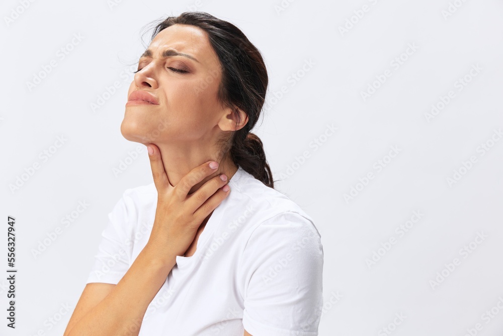 Woman pain throat and back, colds, cold and flu disease, covid-19, in a white t-shirt on a white background Woman pain throat and back, colds, cold and flu disease, covid-19, in a white t-shirt on a white background