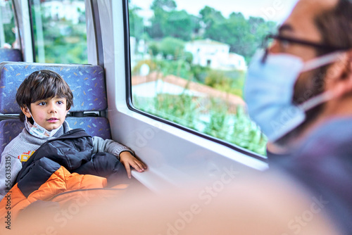 boy travellling in a train with his family photo