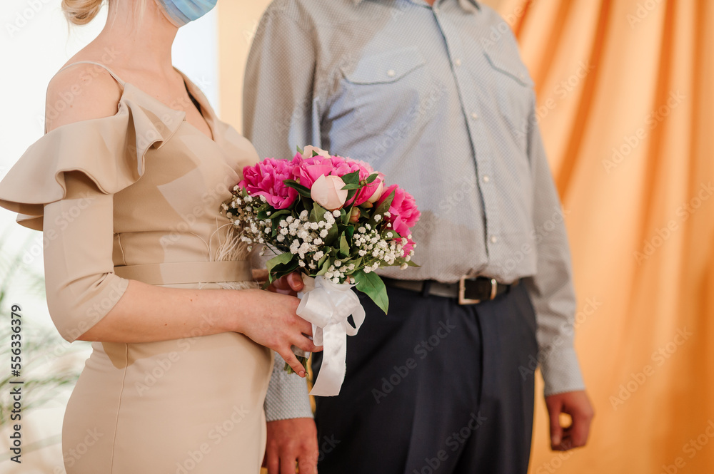 A bouquet of flowers in the hands of the bride. A bouquet of flowers with pink peonies in the hands of a woman. Wedding A bouquet of flowers in the hands of the bride. A bouquet of flowers with pink peonies in the hands of a woman. Wedding