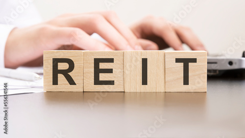man made word reit with wood blocks on the background of the office table. selective focus. business concept.