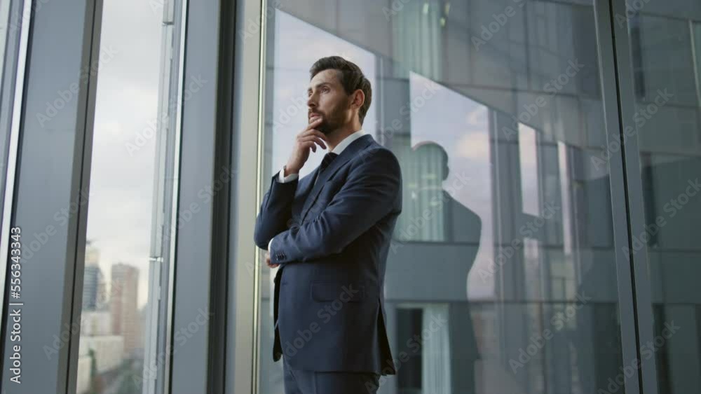 Serious entrepreneur lost thoughts searching problem solution at office window. Serious entrepreneur lost thoughts searching problem solution at office window.