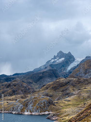 Snowy mountain, lagoon and cloudy sky in Peru South America