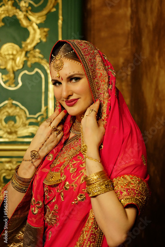 young woman in traditional indian clothing with bridal makeup and jewelry.