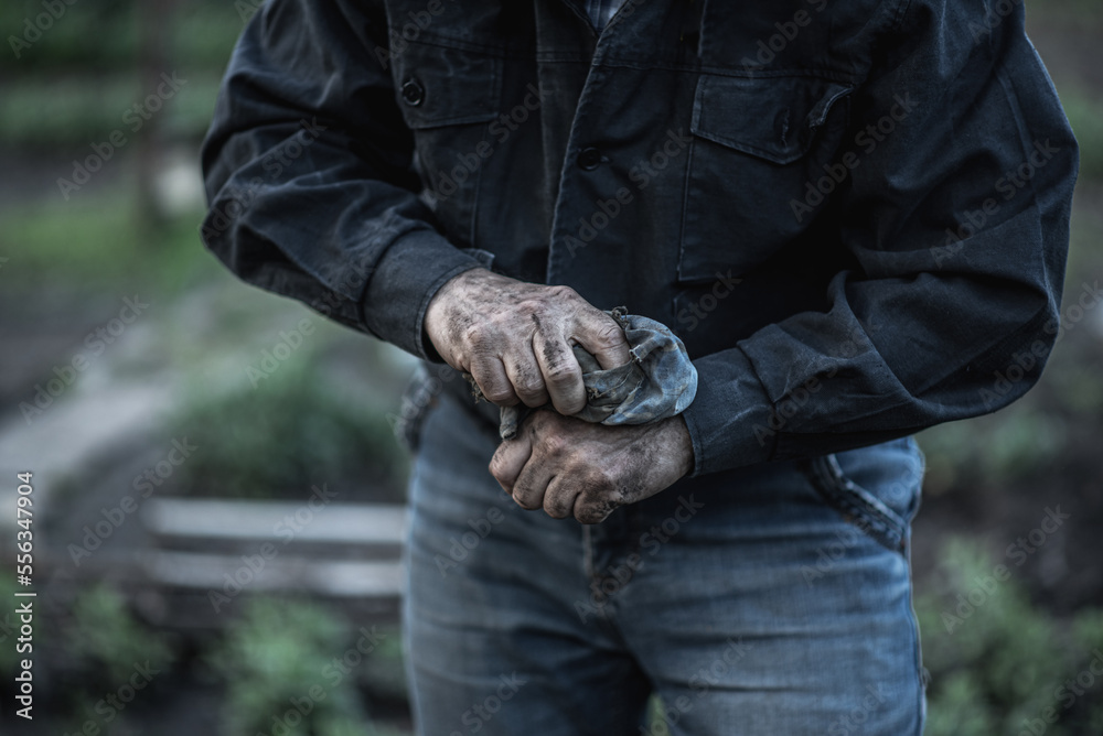 man wipes dirty hands with a rag