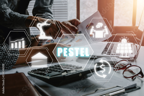 PESTEL analysis concept, political, economic, socio-cultural, technological, environmental and legal, Business team analyzing income charts and graphs with PESTEL icon on virtual screen. © Mongta Studio