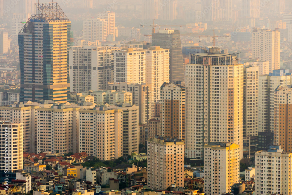 Elevated view of golden light on high rise apartment towers at Hanoi in Vietnam