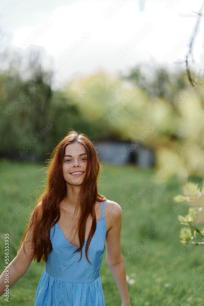 Woman smile with teeth in the spring on a sunny day happily walking in nature against the green grass, the concept of women's body health Woman smile with teeth in the spring on a sunny day happily walking in nature against the green grass, the concept of women's body health