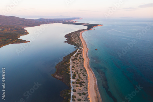 Beautiful aerial vibrant view of Korission Lake Lagoon landscape, Corfu island, Greece with pink flamingos flock, Ionian sea beach and mountains in a summer sunny day