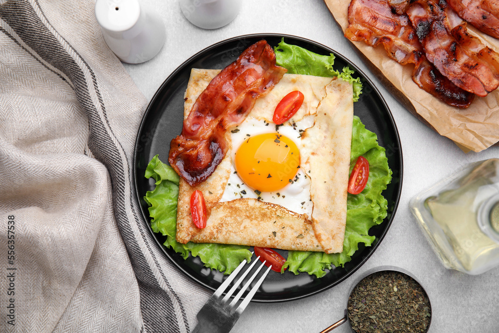 Delicious crepe with egg served on light gray table, flat lay. Breton galette Delicious crepe with egg served on light gray table, flat lay. Breton galette